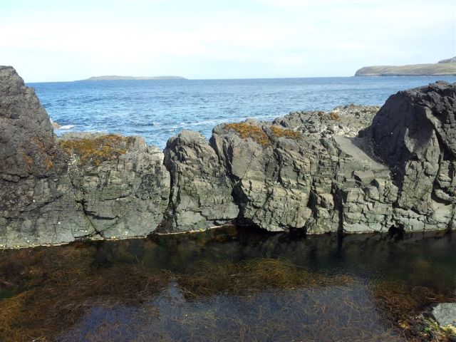 Crystal clear sea pools, the isle of Eilean Trodday over the sea