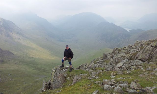 A man & his knee supports on Green Gable, Ennerdale & Buttermere behind A man & his knee supports on Green Gable, Ennerdale & Buttermere behind